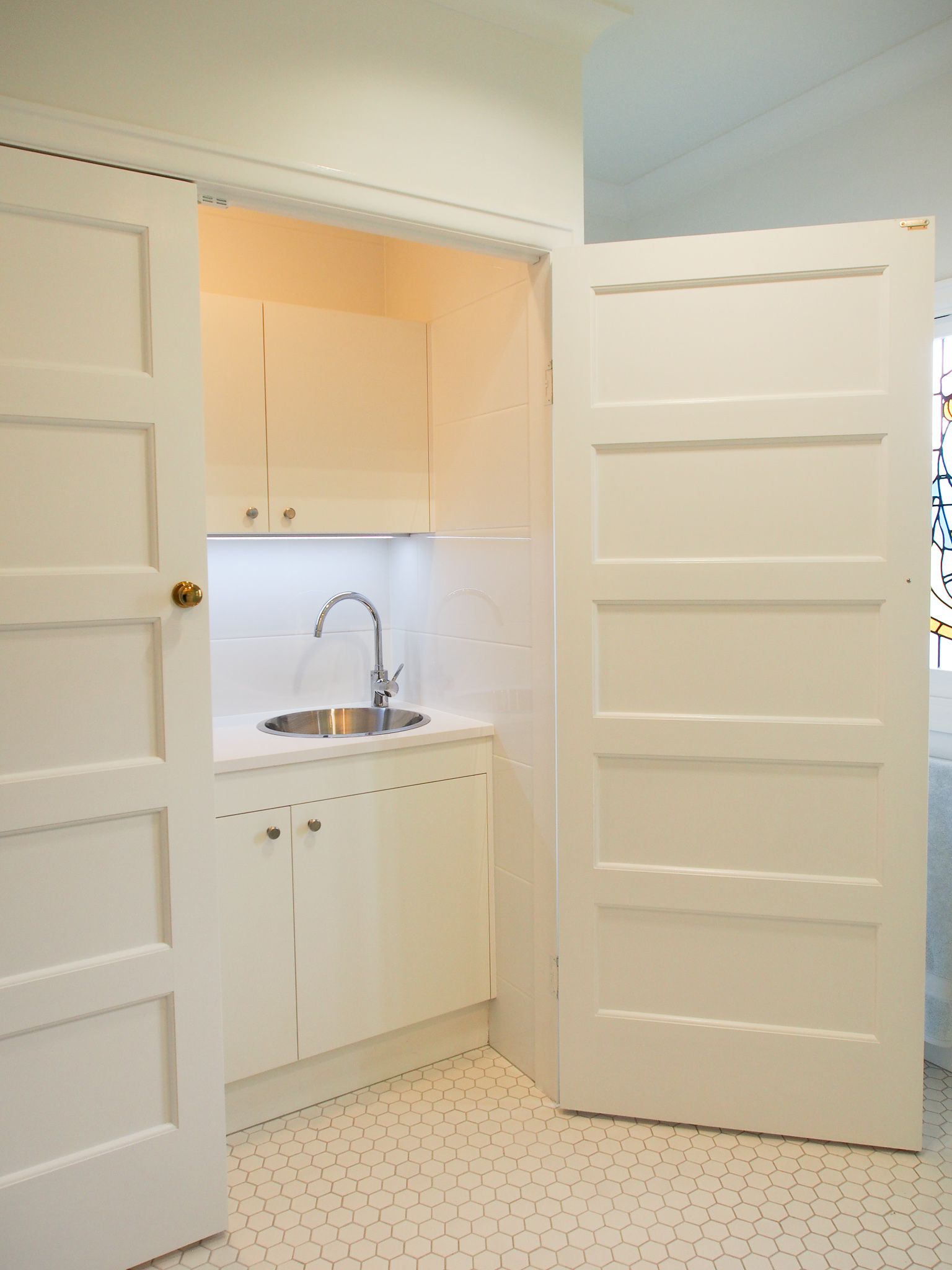 The toilet suite is cleverly hidden away behind the cabinetry to house the laundry Concealed laundry in bathroom