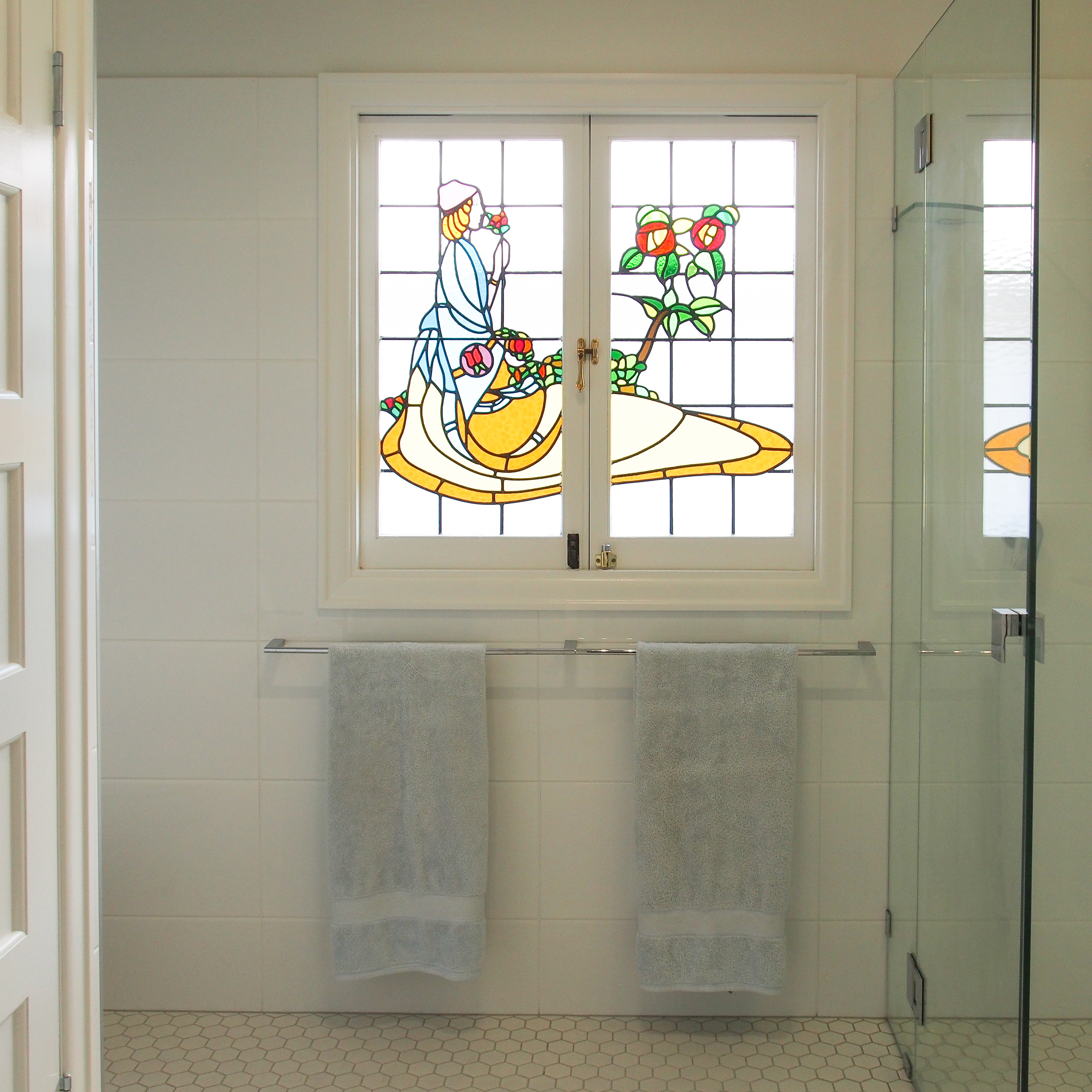 The original stained glass window creates a focal point in this bathroom, and is accentuated by the smart choice of white tiles and fittings Stained glass window feature
