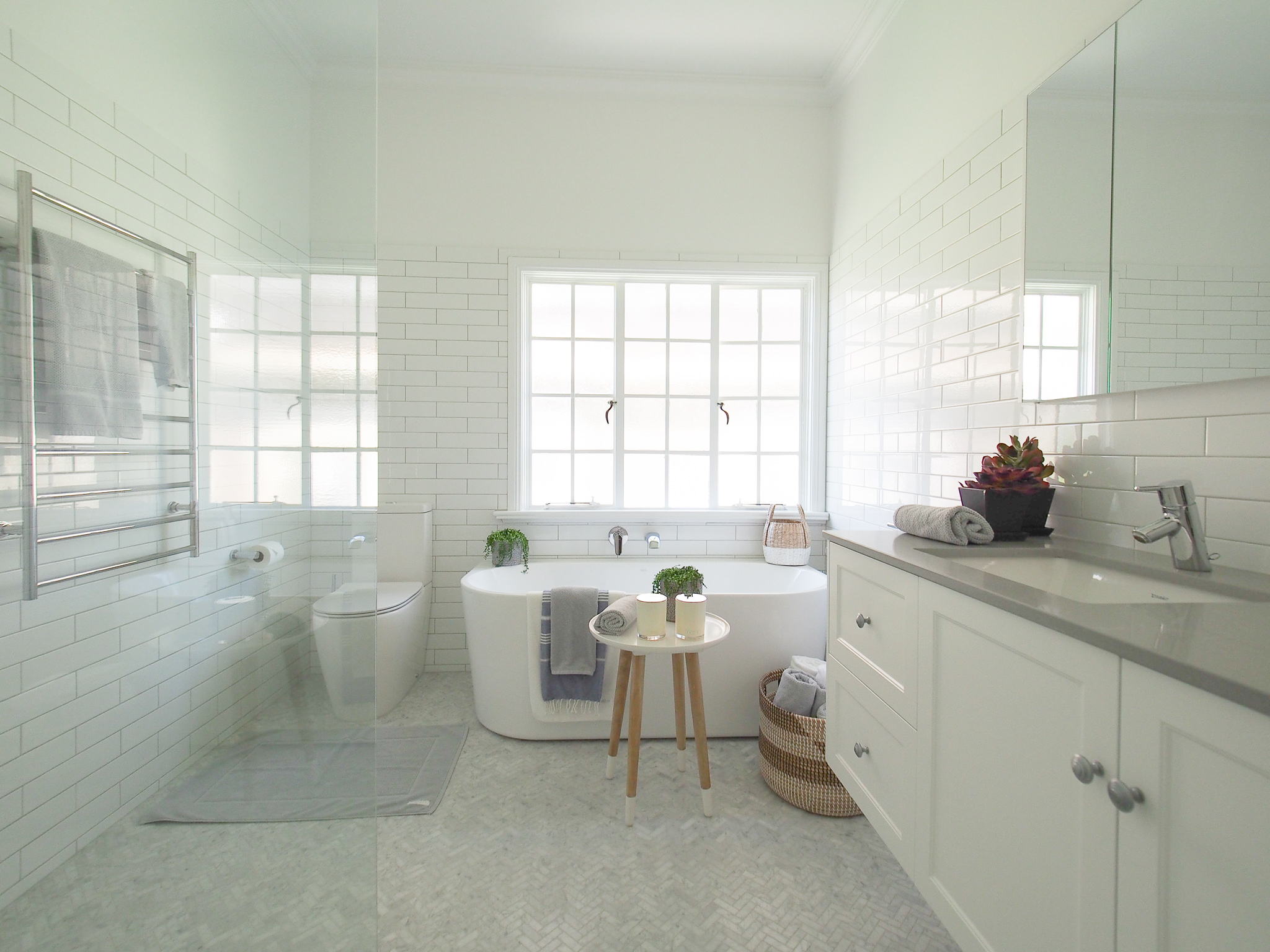 Ascot bathroom ensuite Carrara marble herringbone wall hung vanity shower screen subway tiles free standing bath windows