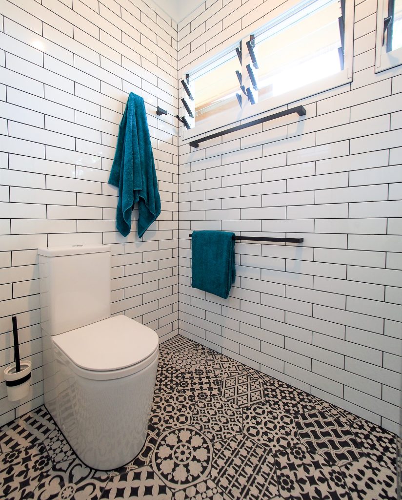 Portrait toilet suite white subway tiles black white patterned floor hexagon louvre
