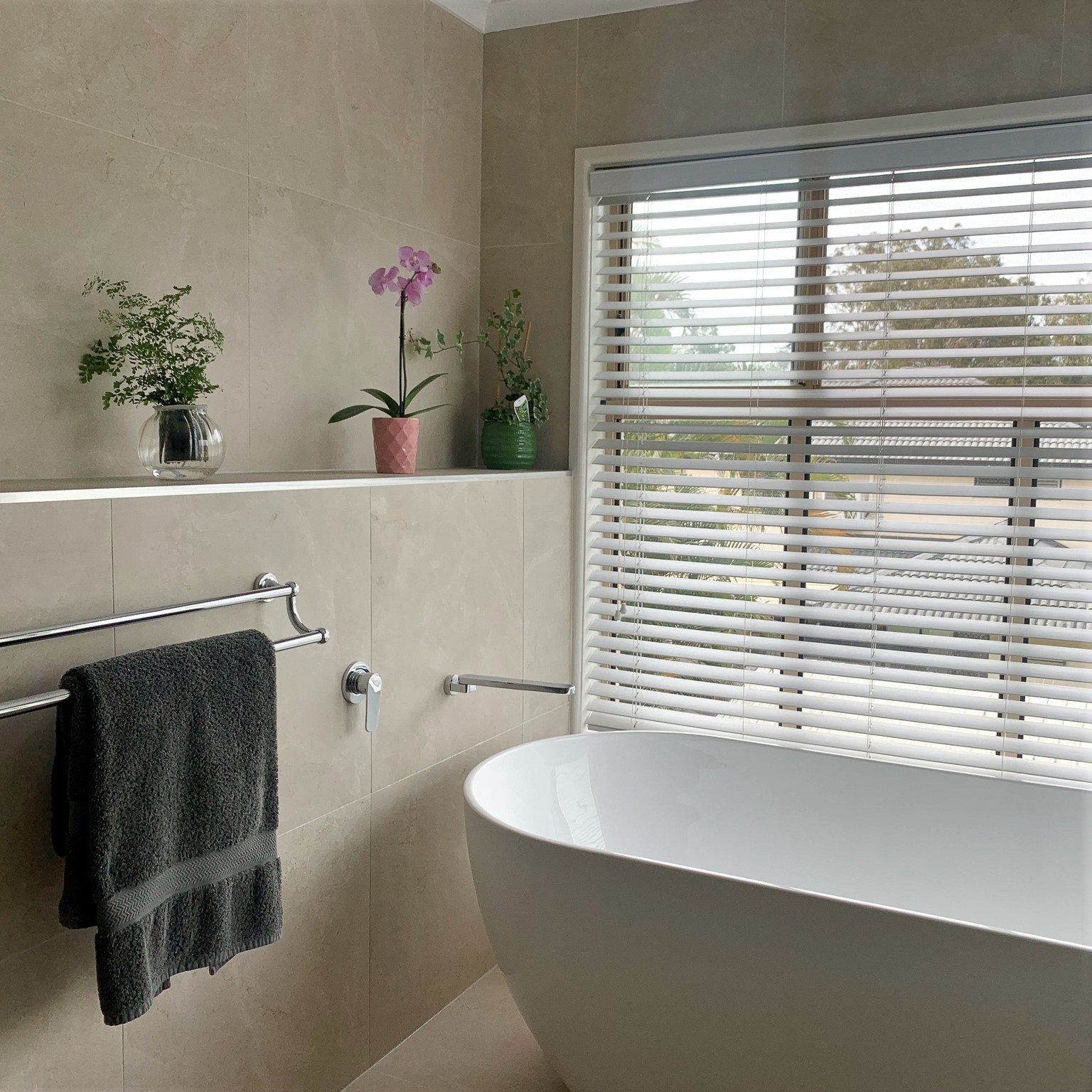 Beige neutral travertine tiles free standing tiles tiled ledge bathroom ensuite towel rails